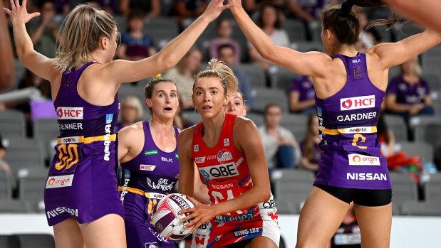 Swamped: Swifts attack Helen Housby surrounded by the Firebirds defence yesterday.