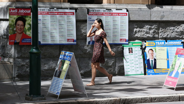 A voter walks past "how to vote" boards, in the absence of volunteers, in Brisbane.