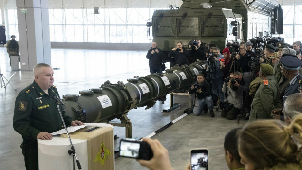 Lieutenant General Mikhail Matveevsky, the chief of the Russian military's missile and artillery forces, speaks during a briefing by the Russian Defence Ministry. A 9M729 land-based cruise missile is displayed near its launcher.