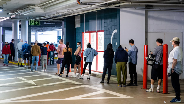 Customers stand in a long queue to get into a Bunnings store in Chatswood on Sunday morning.