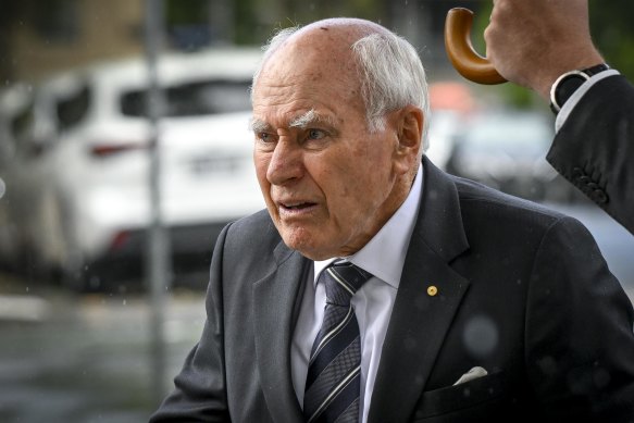 Former prime minister John Howard arrives at the service.