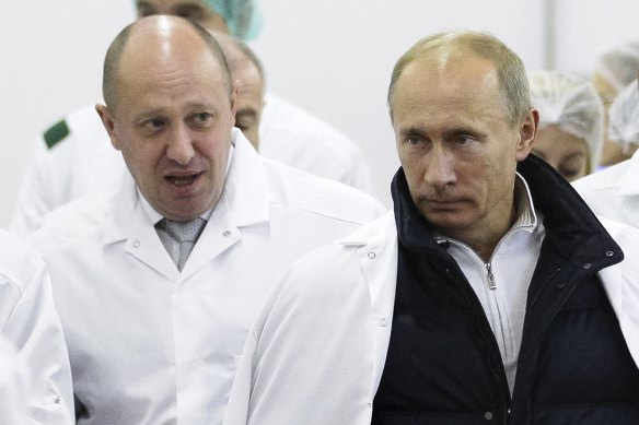 Businessman Yevgeny Prigozhin, left, shows Russian President Vladimir Putin, around his factory which produces school means, outside St. Petersburg, Russia.