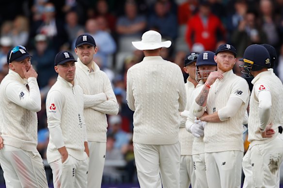 England's players watch the replay of a no-ball delivered to Steve Smith.