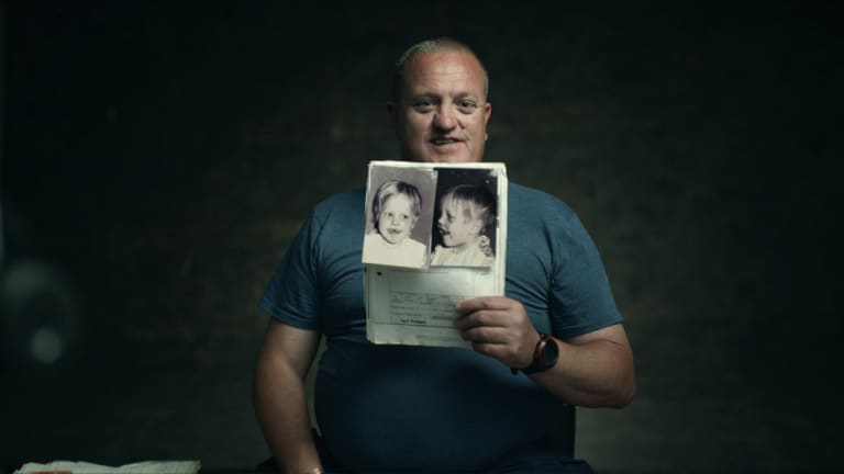 Jason King, the subject of <i>Ghosthunter</i>, holds a photo of himself from his childhood medical files.