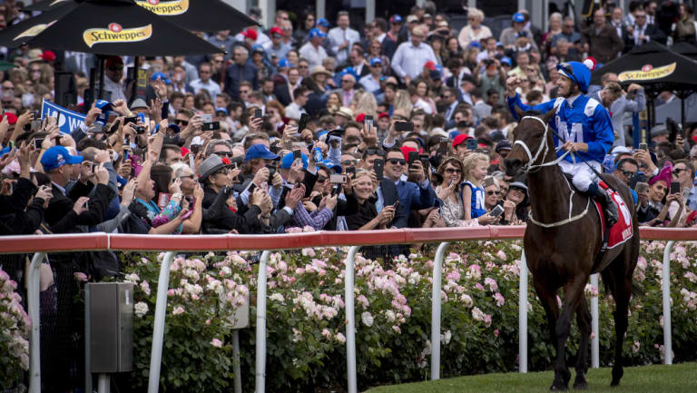 Winx and jockey Hugh Bowman salute the crowd after winning the Cox Plate for the fourth time.
