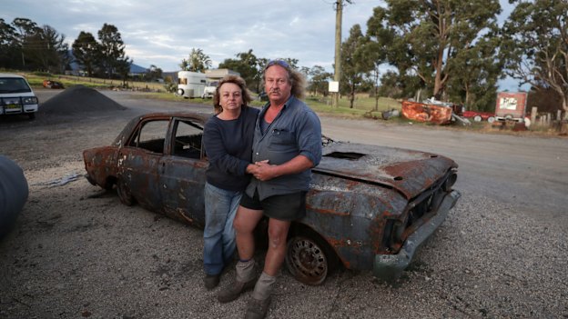 Gail and Brad Rayer with their burnt out 1971 Ford Falcon XY GTHO after bushfires destroyed large parts of their property and auto mechanic business near Cobargo, NSW.