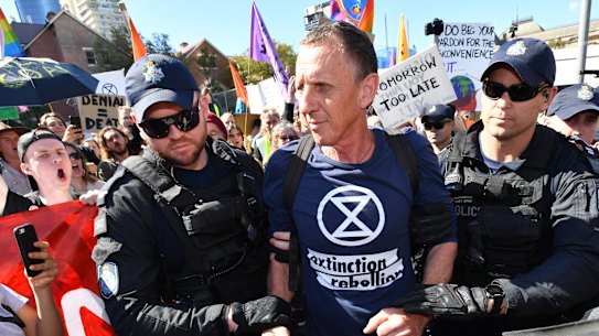 Police arrest an Extinction Rebellion protester after the intersection of Margaret and William streets in Brisbane was blocked earlier this month.