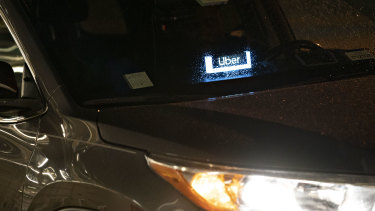 Uber signage is displayed in a vehicle outside Ronald Reagan National Airport in Arlington, Virginia. Uber said in May that it would let passengers and drivers record audio of their rides in an attempt to improve its safety record. 