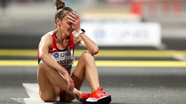 Sviatlana Kudzelich of Belarus reacts after finishing the women's marathon, held at night to avoid the worst of the temperatures.
