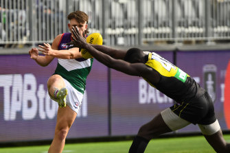 Caleb Serong has his kick smothered by Mabior Chol.