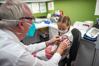Emily Hyslop, 8, received her COVID-19 vaccine from pharmacist Alan Martin at Penrith on Monday.
