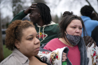 Friends and family comfort Katie Wright, right, near the scene of her son’s fatal shooting.