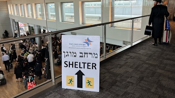 A “shelter” sign is displayed as people wait to board flights at Ben Gurion Airport near Tel Aviv on Monday.