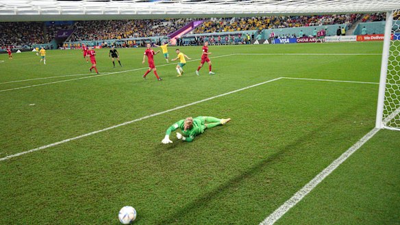 Denmark goalkeeper Kasper Schmeichel  dives to no avail as Leckie’s shot heads for the net.
