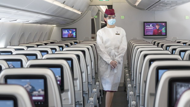 A flight attendant wearing protective equipment on board Qatar Airways. Akbar Al Baker, chief executive of the airline, says the pandemic will force a mindset shift similar to how 9/11 transformed aviation security procedures. 
