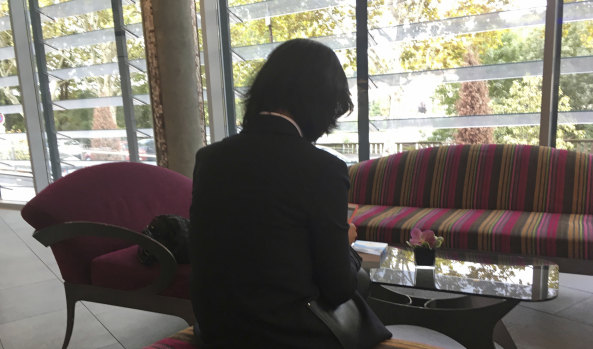 Meng Hongwei's wife Grace Meng, who does not want her face shown, consults her mobile phone in the lobby of a hotel in Lyon, France.