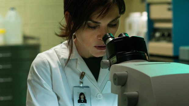 Nancy Jaax (Julianna Margulies) looks at samples in a microscope in her pathology lab. 