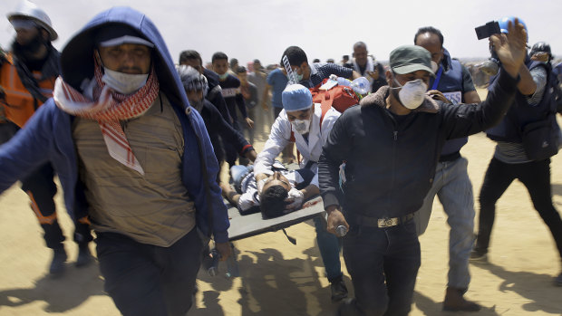 Palestinian medics and protesters evacuate a wounded youth.