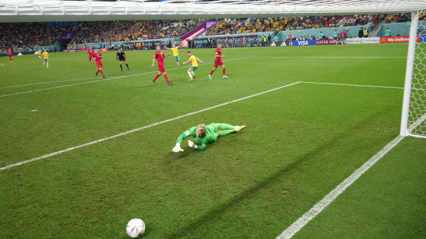 Denmark goalkeeper Kasper Schmeichel  dives to no avail as Leckie’s shot heads for the net.