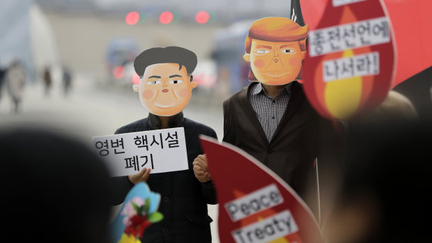 Protesters wearing masks of Donald Trump and Kim Jong-un stand during a rally demanding the denuclearisation of the Korean Peninsula and peace treaty near the US embassy in Seoul, South Korea, on Thursday. 