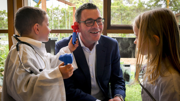 Premier Daniel Andrews gets a check-up from Mitchell and Isabelle at a kindergarten in Pakenham.