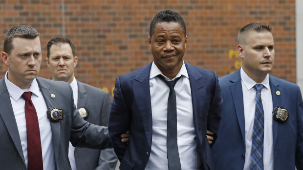 Actor Cuba Gooding Jr., centre, is led by police officers from the New York Police Department's special victims division.