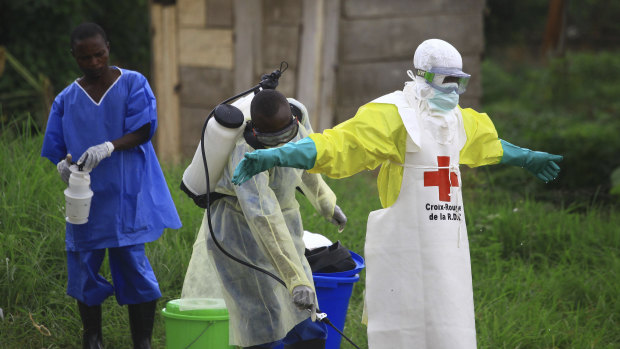 A health worker sprays disinfectant on his colleague after working at an Ebola treatment centre in Beni, Eastern Congo. 