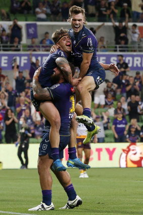 Cameron Munster celebrates a try with Kenny Bromwich and Ryan Papenhuyzen.
