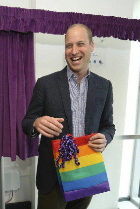 Prince William reacts to receiving a rainbow gift bag from trust chief executive officer Tim Sigsworth.