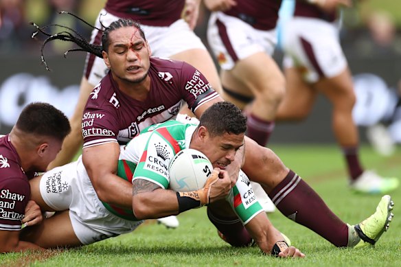 A bloodied Marty Taupau tries to stop Souths’ Dane Gagai.