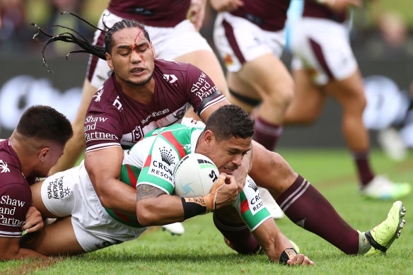 A bloodied Marty Taupau tries to stop Souths’ Dane Gagai.