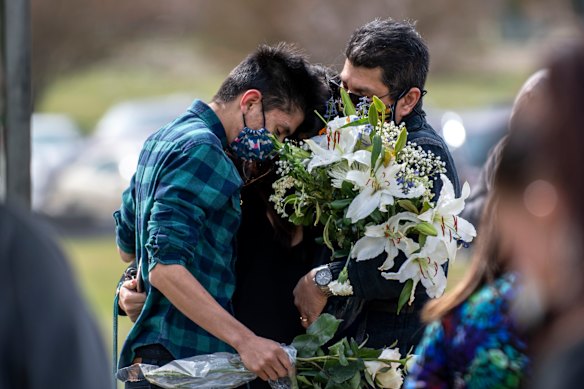 Juan Carlos Rangel, left, hugs his mother Beatriz and father Carlos during Beatriz's father's burial ceremony in Greeley, Colorado. The longtime JBS employee was the first to die of COVID-19 at the JBS meat processing plant. 