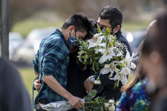 Juan Carlos Rangel, left, hugs his mother Beatriz and father Carlos during Beatriz's father's burial ceremony in Greeley, Colorado. The longtime JBS employee was the first to die of COVID-19 at the JBS meat processing plant. 