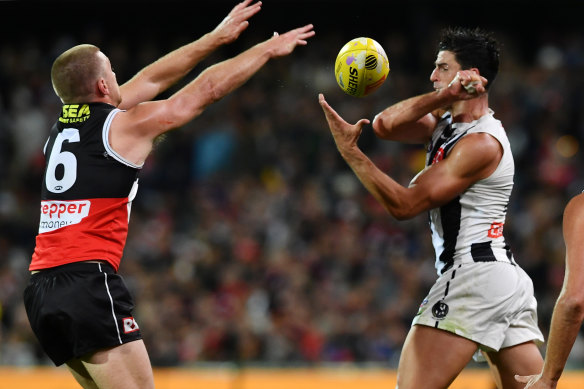 Scott Pendlebury handballs past Sebastian Ross. 