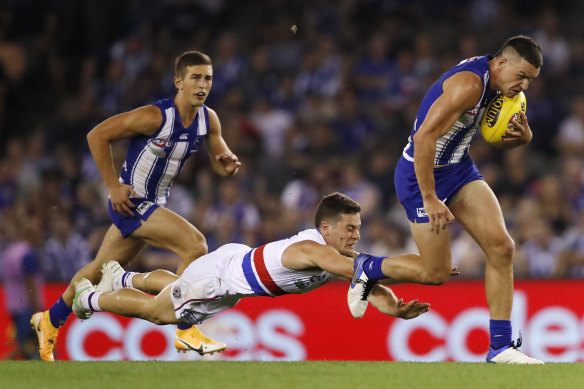 The Kangaroos’ Luke Davies-Uniacke on the run as Josh Dunkley dives to tackle.