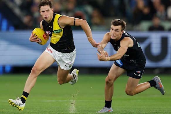 Debutant Sam Grlj of the Tigers fends of Jagga Smith of the Blues.