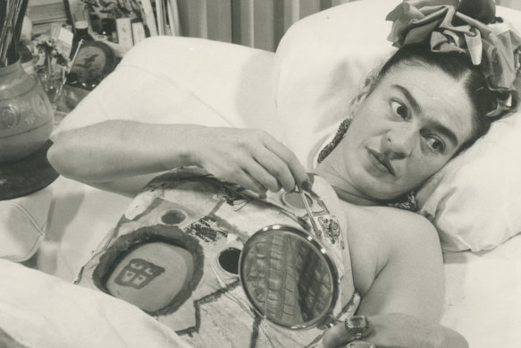 Frida at ABC Hospital holding a mirror, Mexico, 1950.