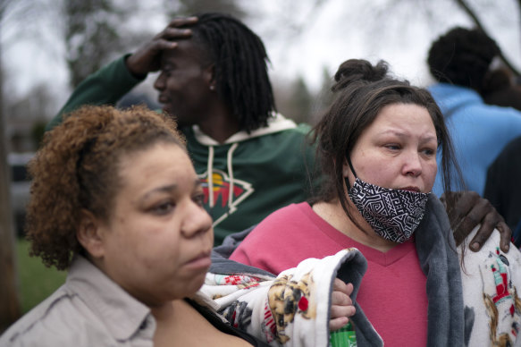 Friends and family comfort Katie Wright, right, near the scene of her son’s fatal shooting.