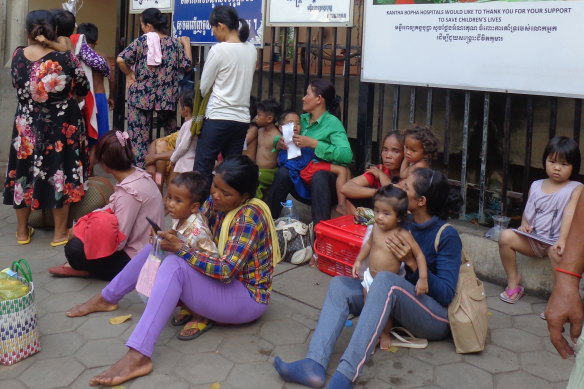 Families of sick children are queued up outside the gates of Phnom Penh's Kantha Bopha hospital.