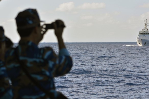 Vietnamese sailors watch the approach of a Chinese coast guard vessel near the Paracel Islands.