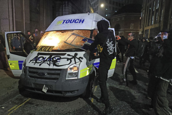 Protesters set fire to a vandalised police van outside Bridewell Police Station, in Bristol.