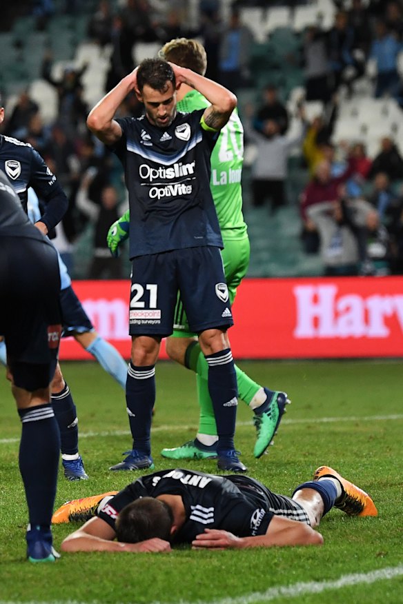 Terry Antonis of the Victory (right) lays on the ground after his own goal.