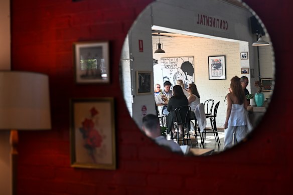 The dining area is lined in warm wood and decorated with vintage prints.