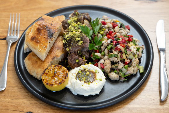 Slow-cooked lamb shoulder is served with labne and different salads each day.