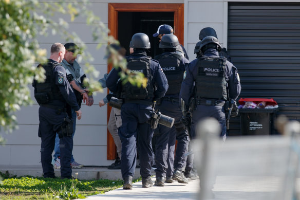 Riot police swarm a Colyton house in west Sydney under Operation Amarok