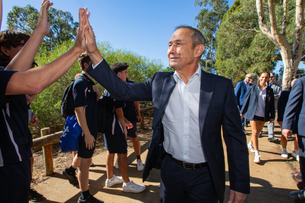 Cook high-fiving Greenwood College students.