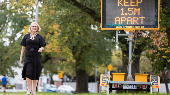 Melbourne lord mayor Sally Capp next to a sign urging social distancing.