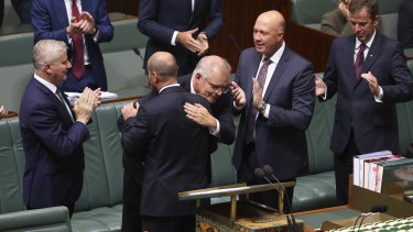 Treasurer Josh Frydenberg is congratulated by Prime Minister Scott Morrison and other colleagues after delivering his budget speech. Denniss says no other country has been as obsessed with the existence and size of its budget surpluses.