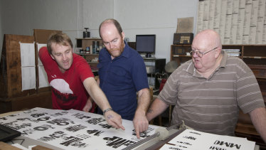 Monash University's Warren Taylor, centre, and printworker Laurie Harding, right, with some of the exhibits at the 2009 fundraiser in Footscray.