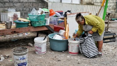 A woman who used to run a food store on the Sari Club site collects her belongings in preparation for leaving.